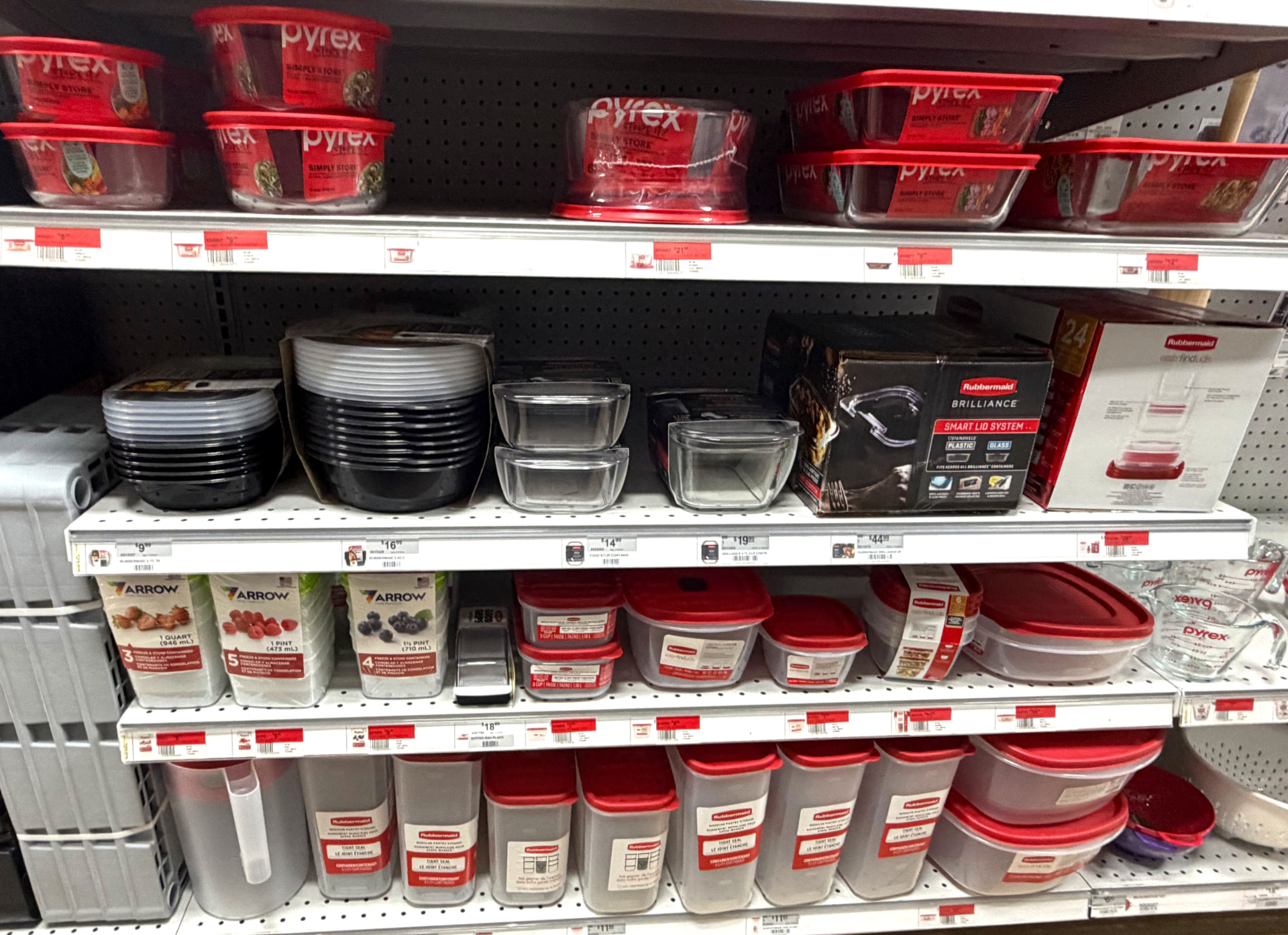 Shelves of Pyrex glass and Rubbermaid plastic food storage containers and pantry canisters