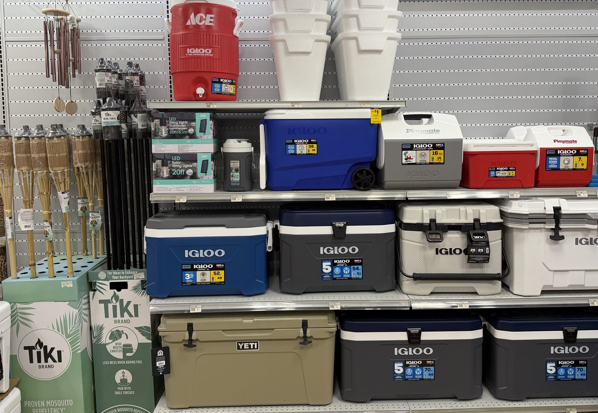Shelves featuring Igloo and Yeti coolers, Tiki Brand torches, and Ace water jugs at Hessler Paint & Hardware in Delray Beach, Florida.